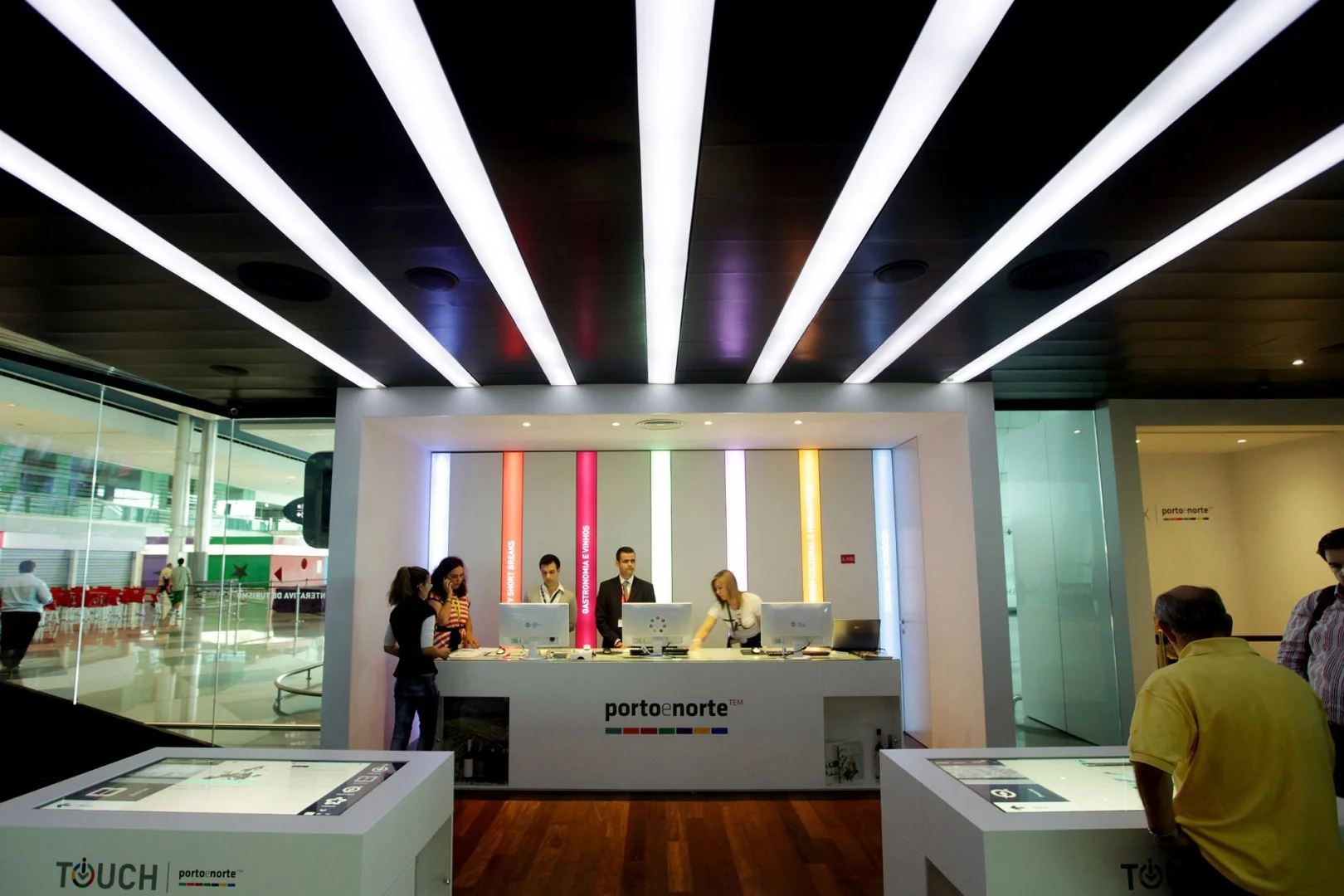 Porto e Norte tourism counter with staff and interactive screens.