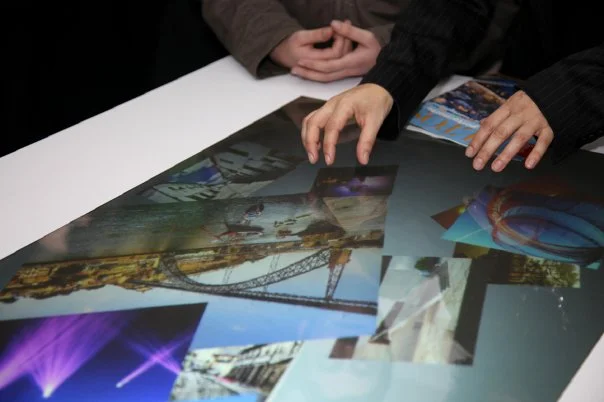 Visitors browsing digital photography on a multitouch table.